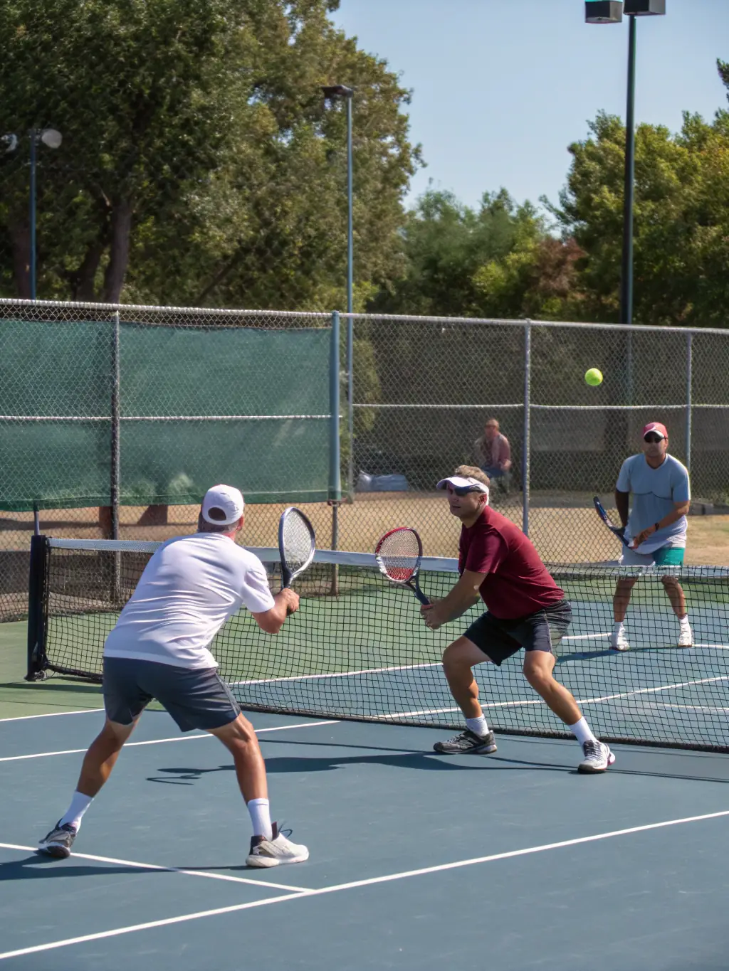 A group of senior players enjoying a friendly tennis match, highlighting the social and health benefits of the sport.